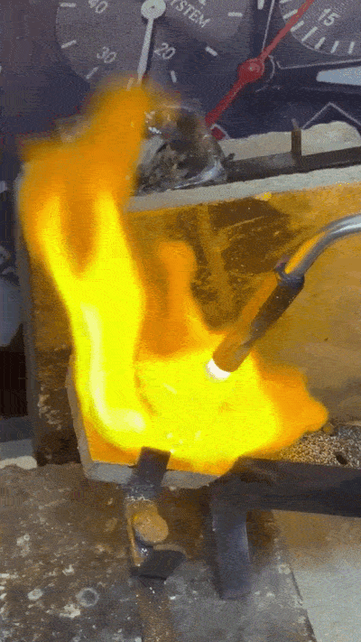 Goudsmid smelt edelmetaal in een smeltkroes als voorbereiding op een nieuw handgemaakt sieraad.
